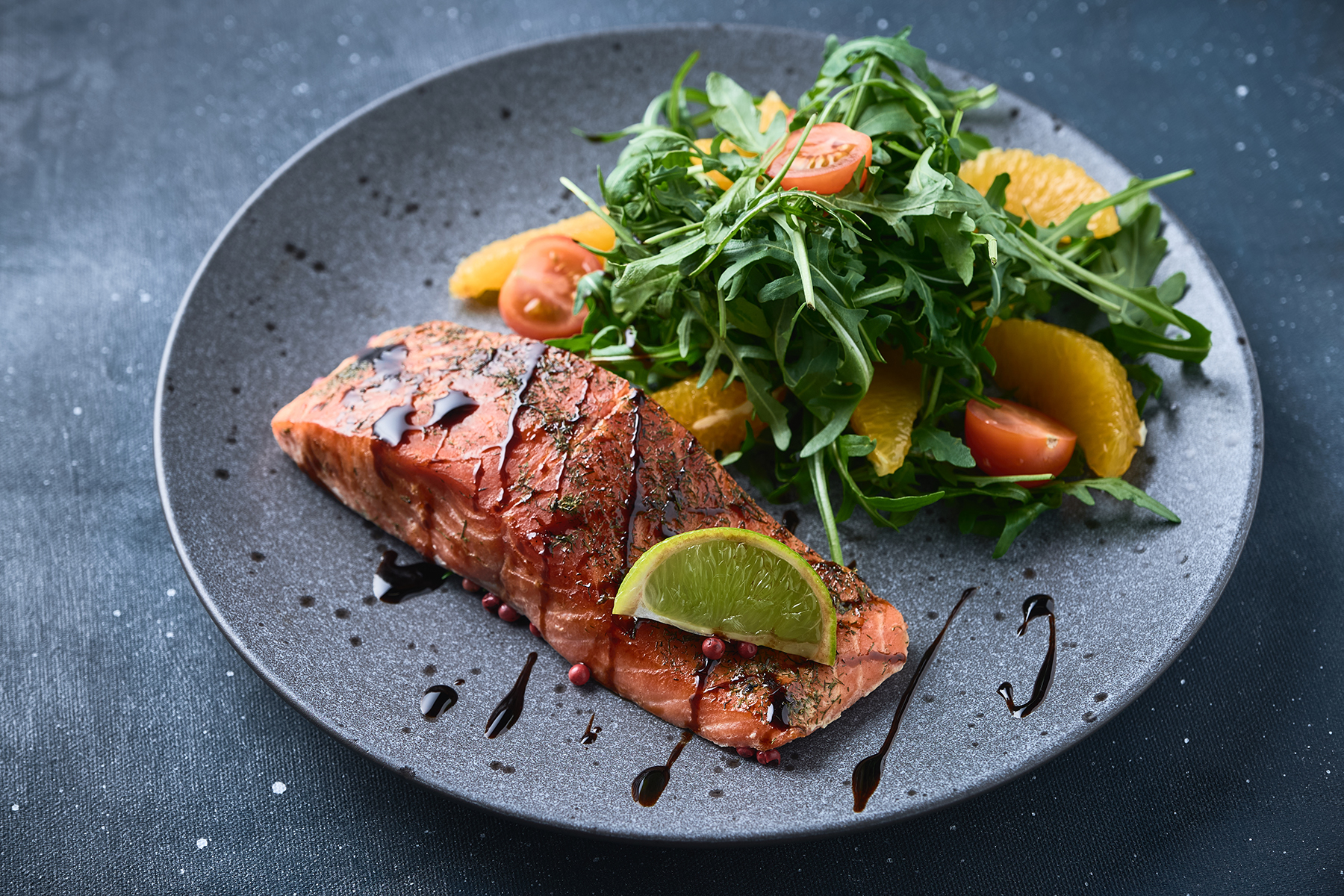 Salmone con insalata di rucola, pomodorini e arancia